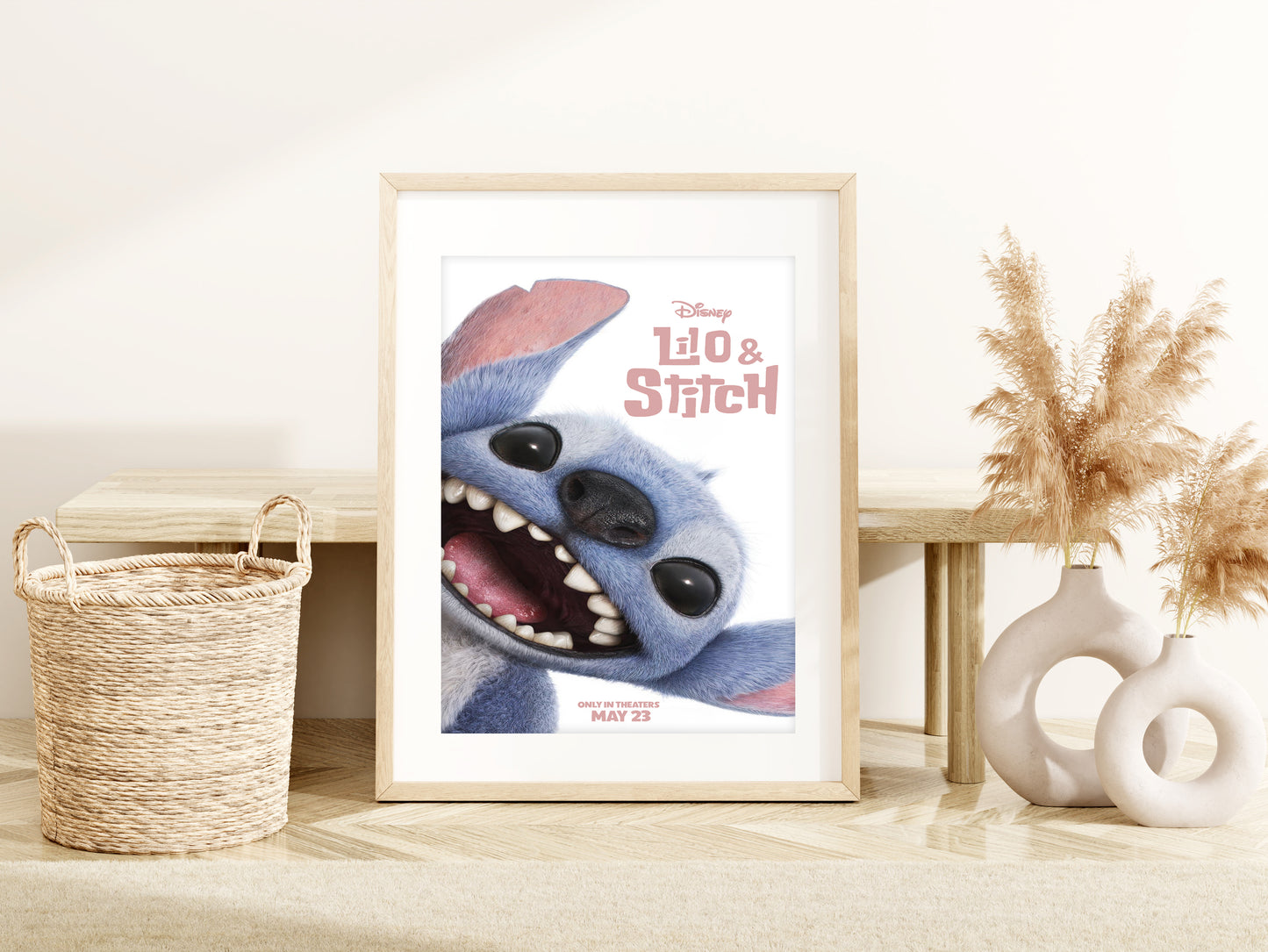 Framed poster of a Stitch character on a wall with decor items below.ovie 2025